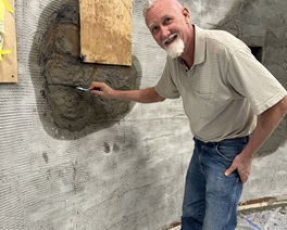 Luis Sabor works on the finish for the mission wall